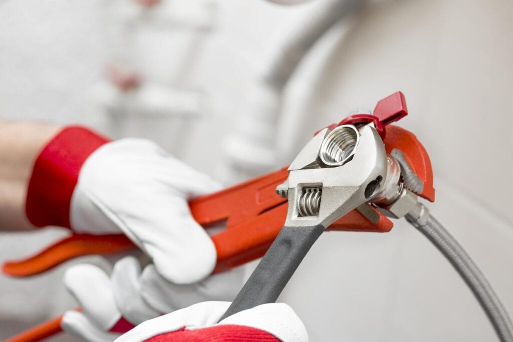 Plumber holding pipe wrenches for an emergency repair in Davenport