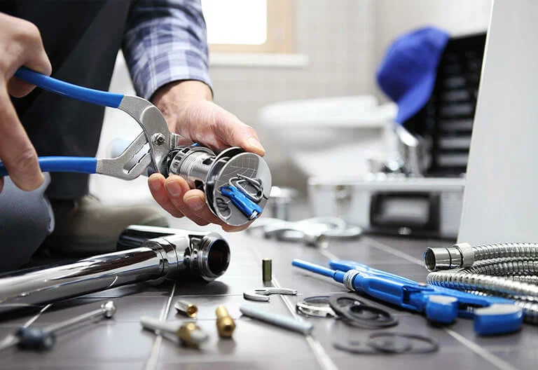 Technician repairing a plumbing fixture with professional tools in Davenport