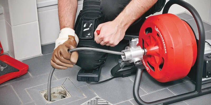 Plumber using a drain-cleaning machine in Davenport
