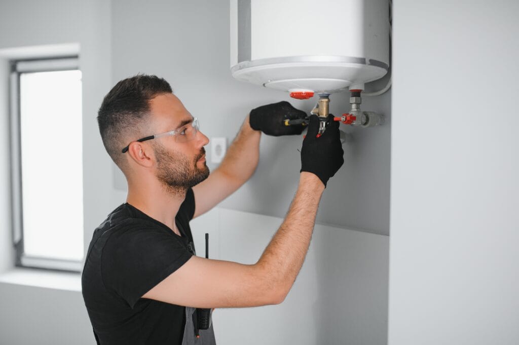 Technician performing water heater maintenance in Davenport