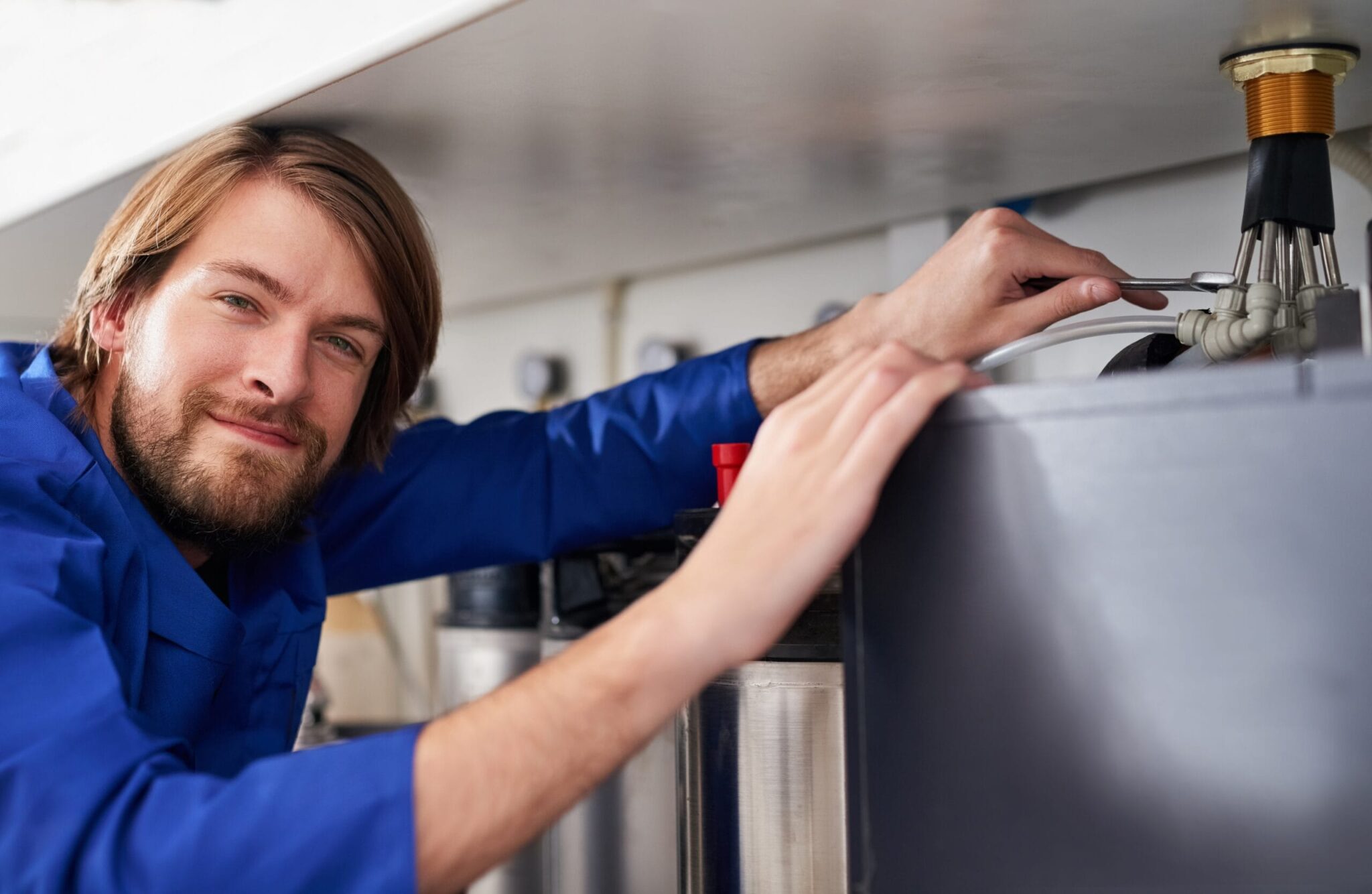 Technician servicing a residential water heater tank in Davenport