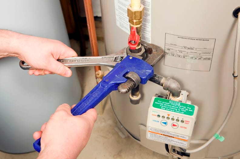 Plumber repairing a water heater valve in Davenport